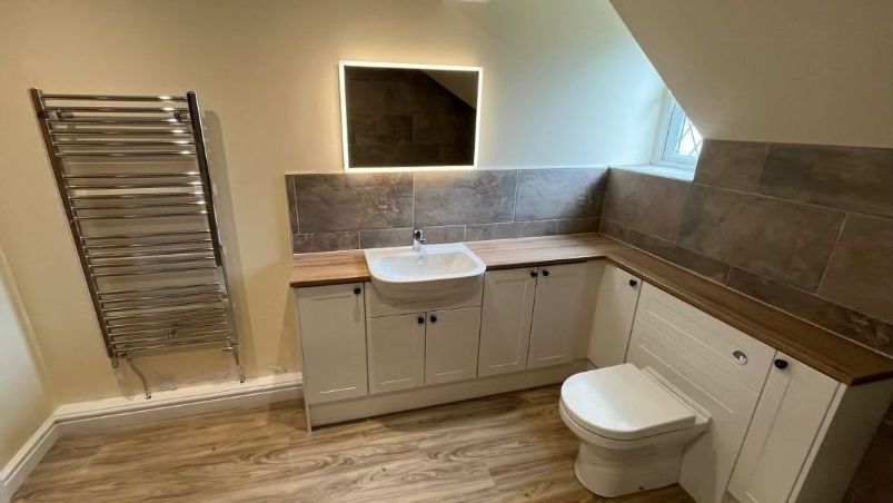 Bathroom Installation & Plumbing Services by Gazand Plumbing Contractors Plumber installing bathroom sink and pipework, showcasing Gazand Plumbing Contractors services